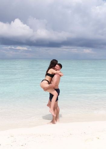 A couple embracing on an empty white beach