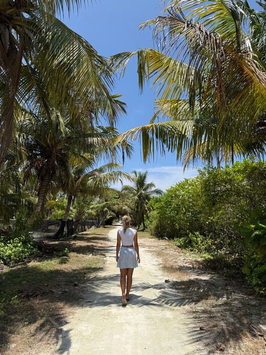Walking a sandy path through island greenery